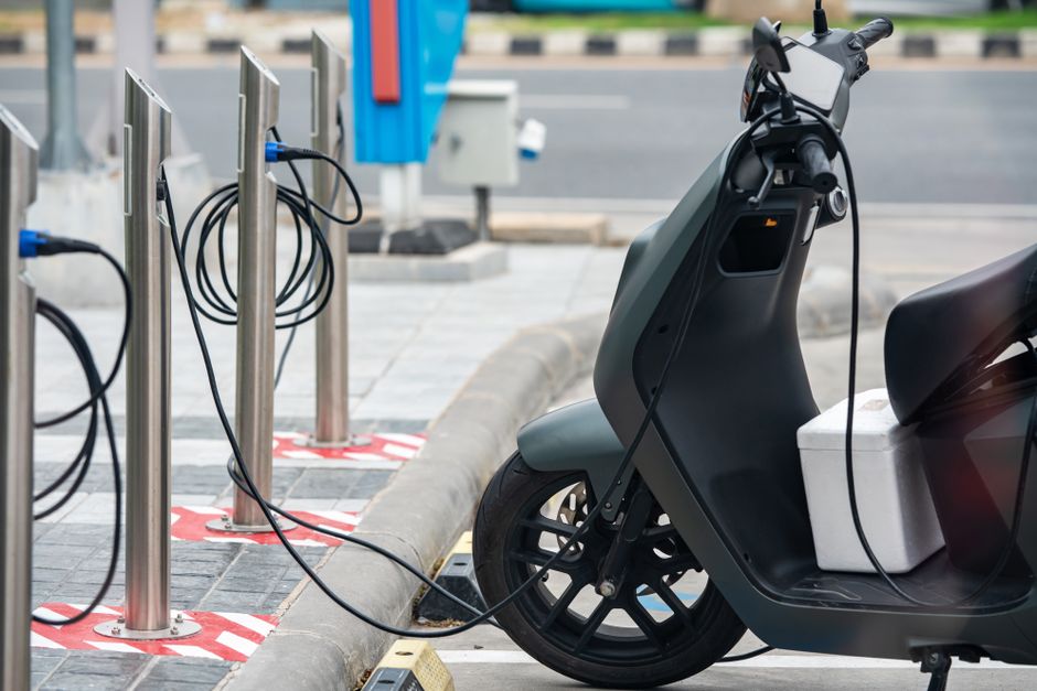 Enfant conduisant un quad électrique coloré dans un jardin, avec casque de protection