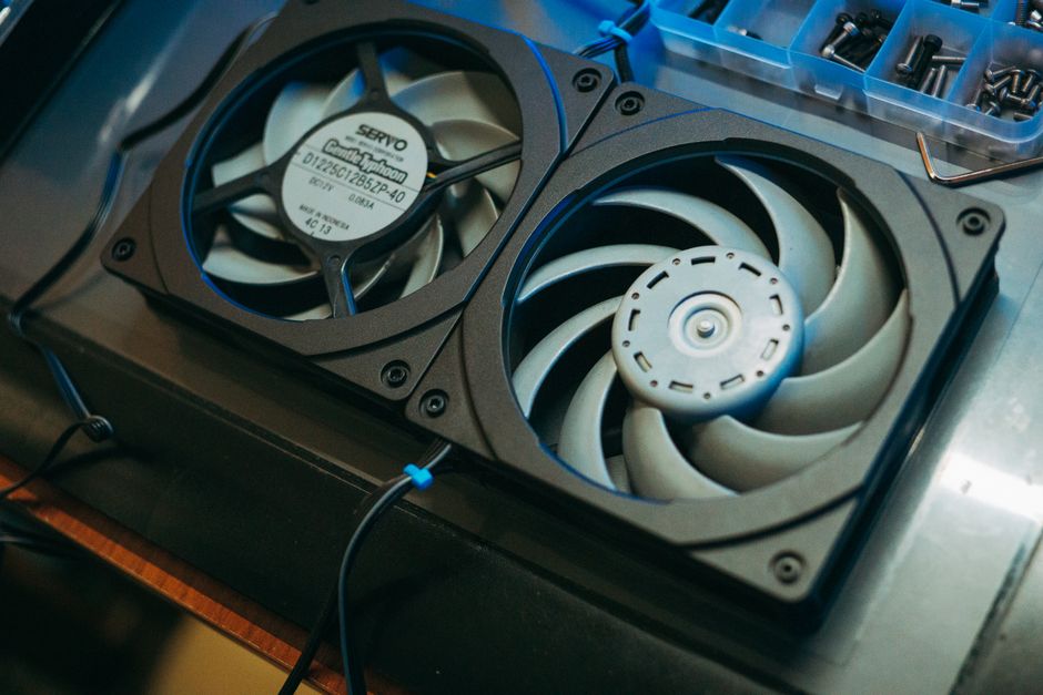Ventilateur thermique noir posé sur un poêle à bois moderne dans un salon chaleureux
