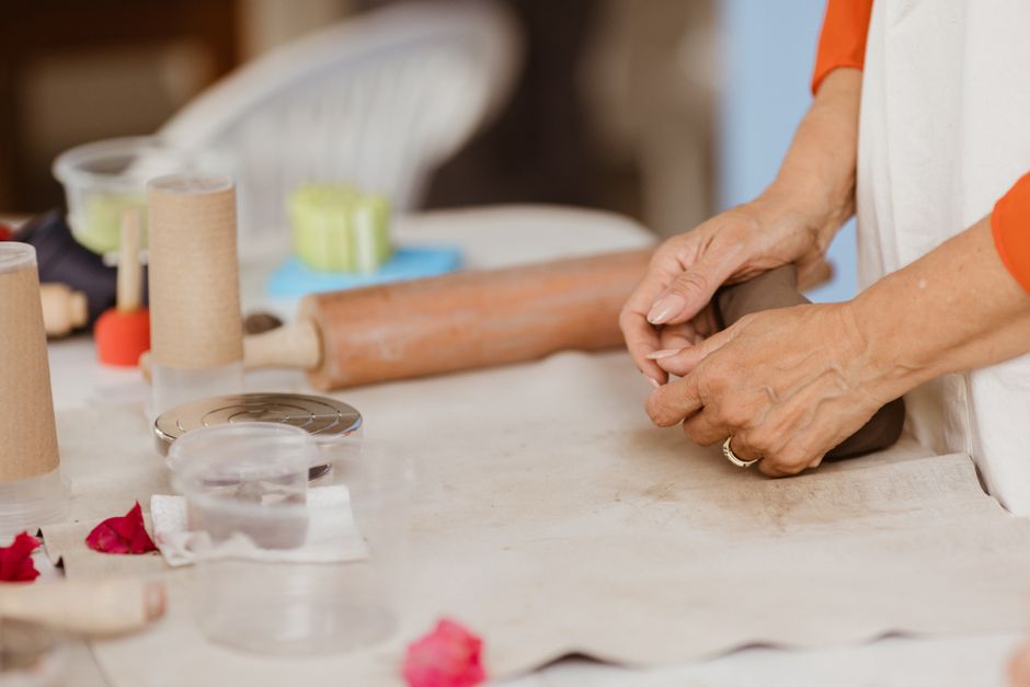 Enfant modelant de la pâte à sel colorée sur une surface de travail, avec des formes en cours de création