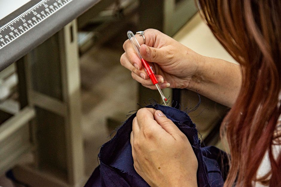 Gros plan sur une poche cousue d'un manteau avec fil de bâti blanc